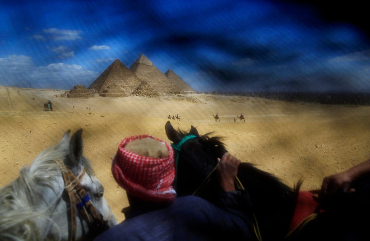 Un hombre guía los turistas hacia las pirámides de Guiza, cerca de El Cairo. La fotografía fue tomada a través de un Nicab, velo que cubre el rostro y hace parte de la vestimenta musulmana femenina del hiyab. (AP/Hassan Ammar)