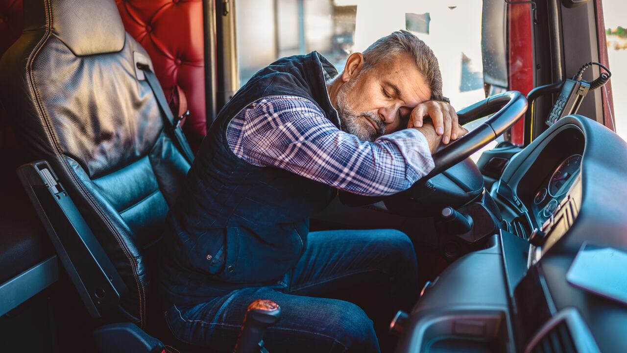 Conductor de camión exhausto quedándose dormido en el volante.
