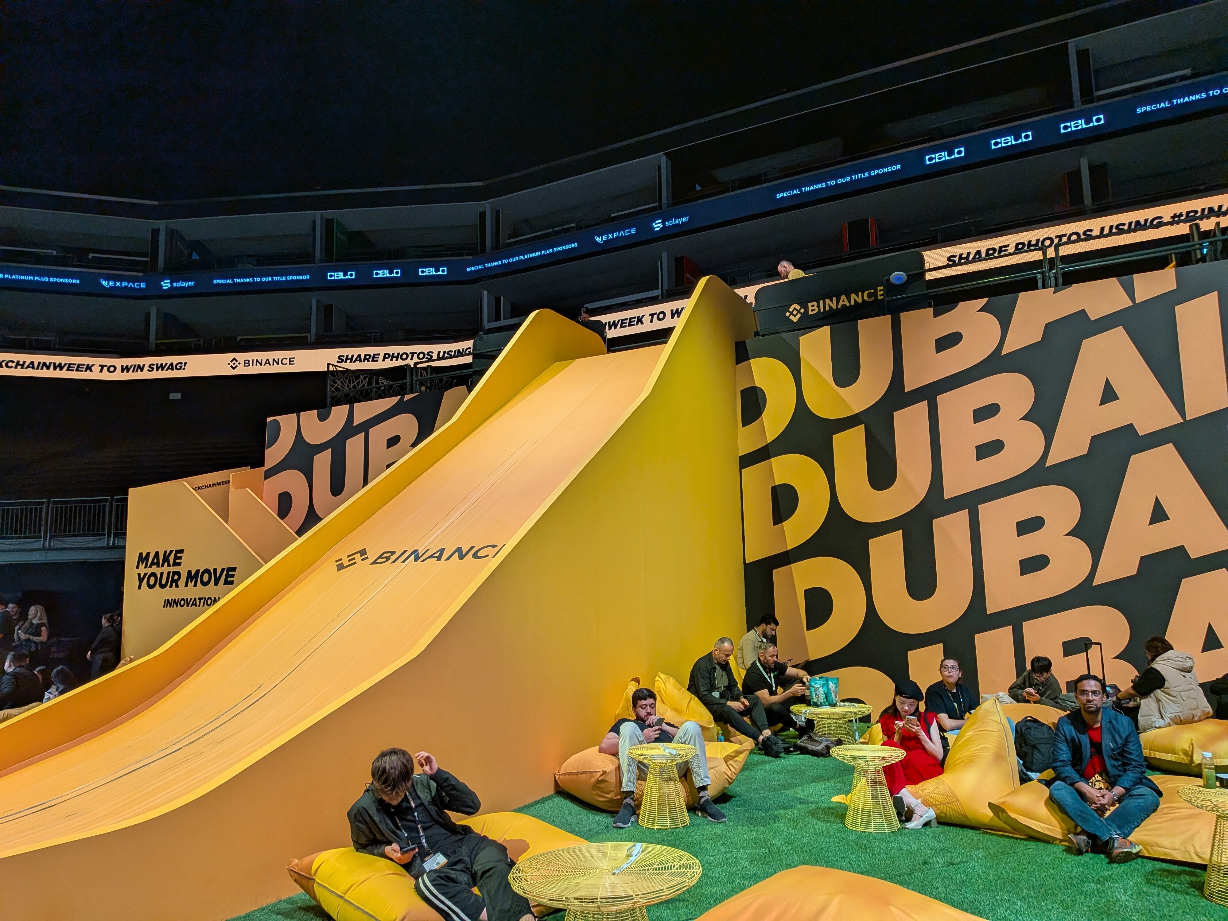 Participantes interactúan con la resbaladilla gigante diseñada para la Binance Blockchain Week 2025, uno de los espacios creados para fomentar la diversión y las pausas activas.
