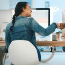 Vista trasera de dos jóvenes diseñadores dándose un puñetazo en una oficina