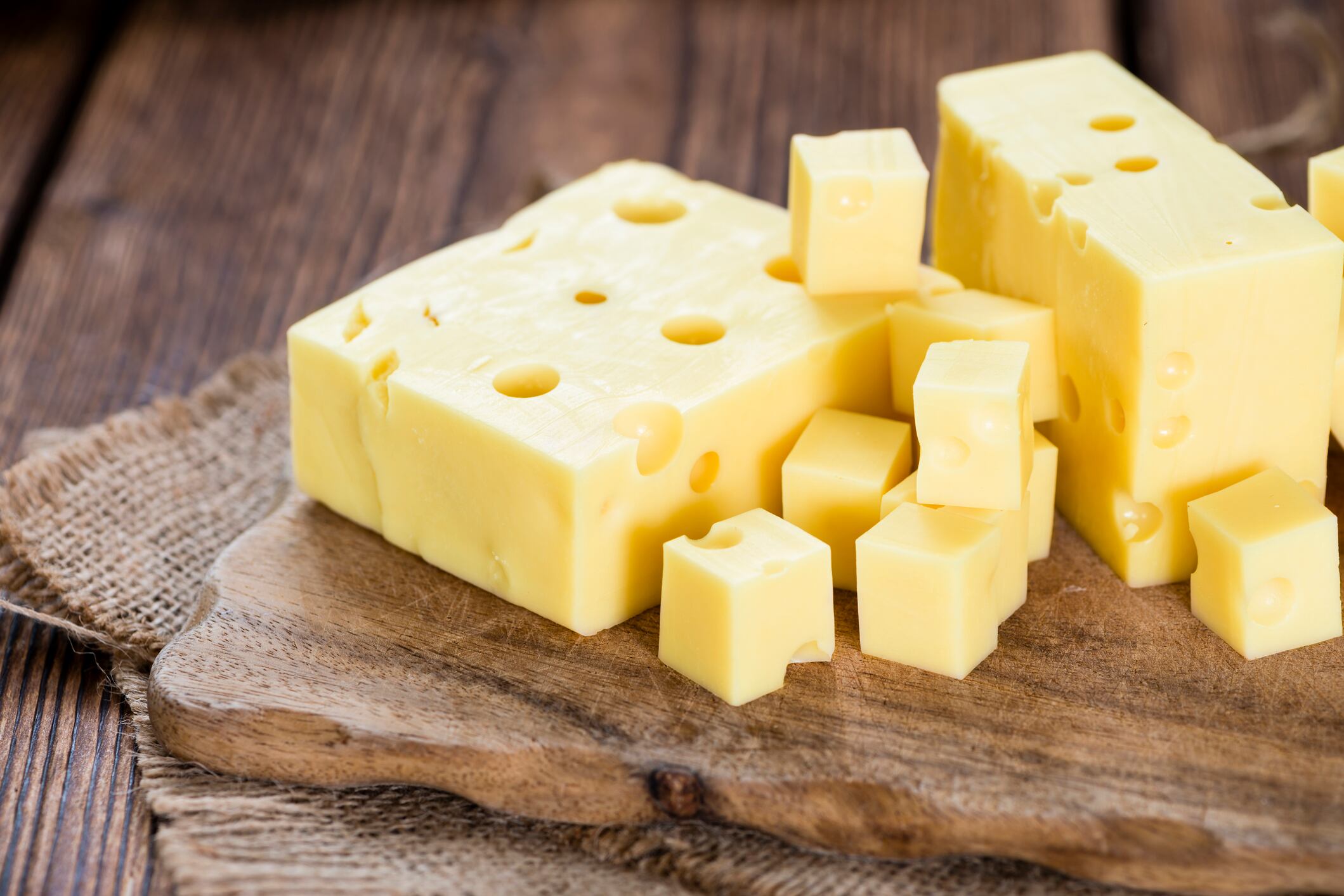 Portion of Cheese (close-up shot) on rustic wooden background