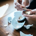 Foto de una persona contando monedas tras romper una alcancía