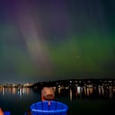 Un grupo de personas admira la aurora boreal que ilumina el lago Washington, en Renton.