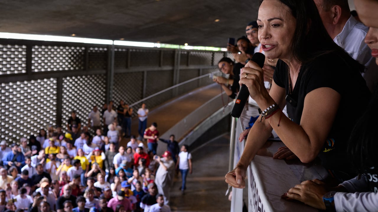 La líder de la oposición venezolana María Corina Machado habla con estudiantes junto al candidato presidencial venezolano Edmundo González (R-cubierto) durante un mitin de campaña en la Universidad Central de Venezuela en Caracas.