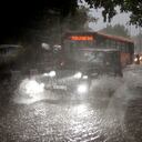 Los vehículos circulan por una calle anegada durante un fuerte aguacero en Nueva Delhi, India, el domingo 9 de julio de 2023.