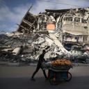 A Palestinian man walks past the destroyed Al-Shuruq building in Gaza City on May 20, 2021 after it was bombed by an Israeli air strike. - Israel and the Palestinians are mired in their worst conflict in years as Israel pounds the Gaza Strip with air strikes and artillery, while Hamas militants fire rockets into the Jewish state. (Photo by MAHMUD HAMS / AFP)