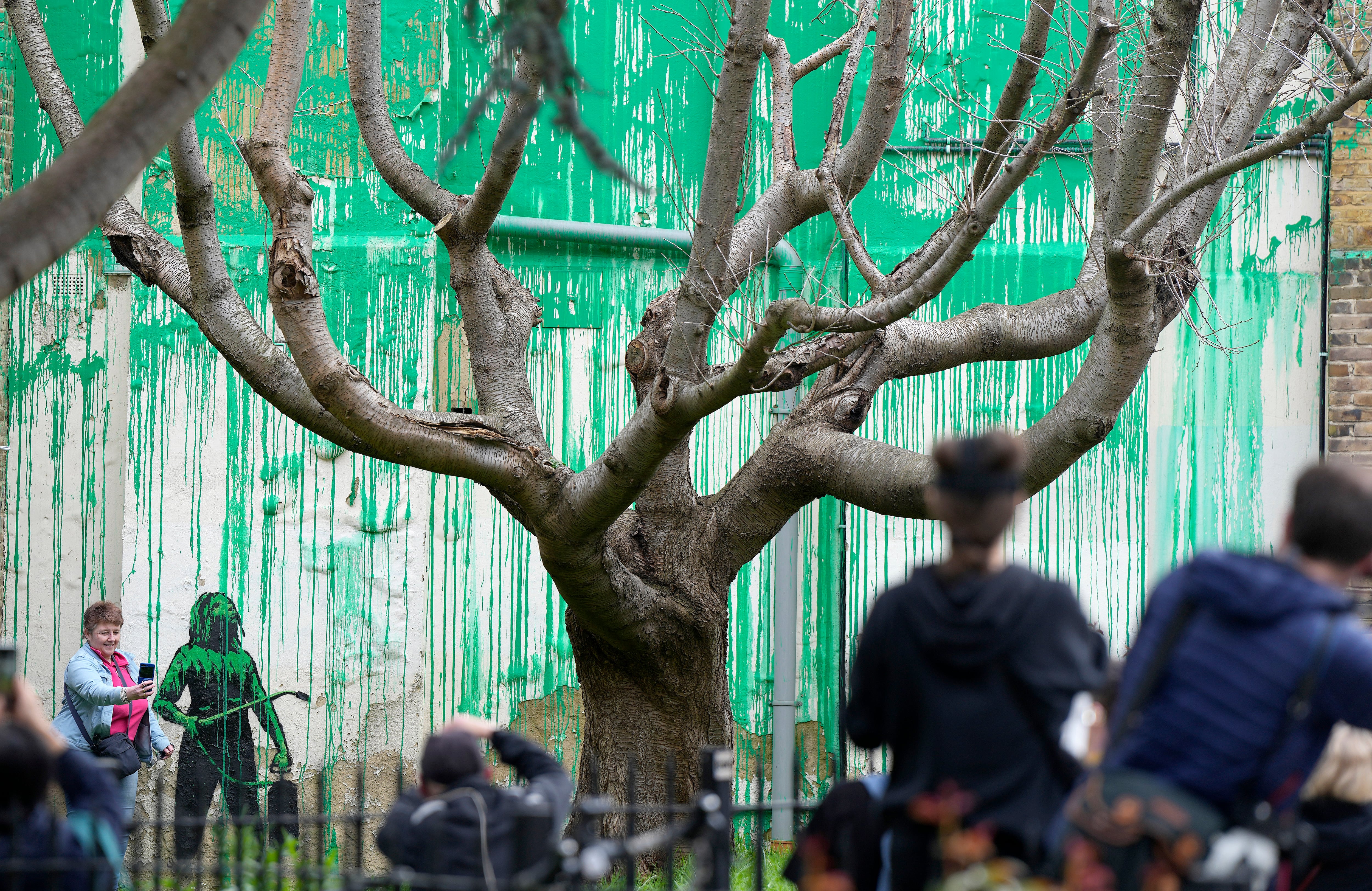 La gente mira una nueva pintura de Banksy en una pared en Londres, el lunes 18 de marzo de 2024. Un nuevo mural de Banksy atrajo multitudes a una calle de Londres el lunes, incluso antes de que el esquivo artista de graffiti confirmara que la obra era suya.