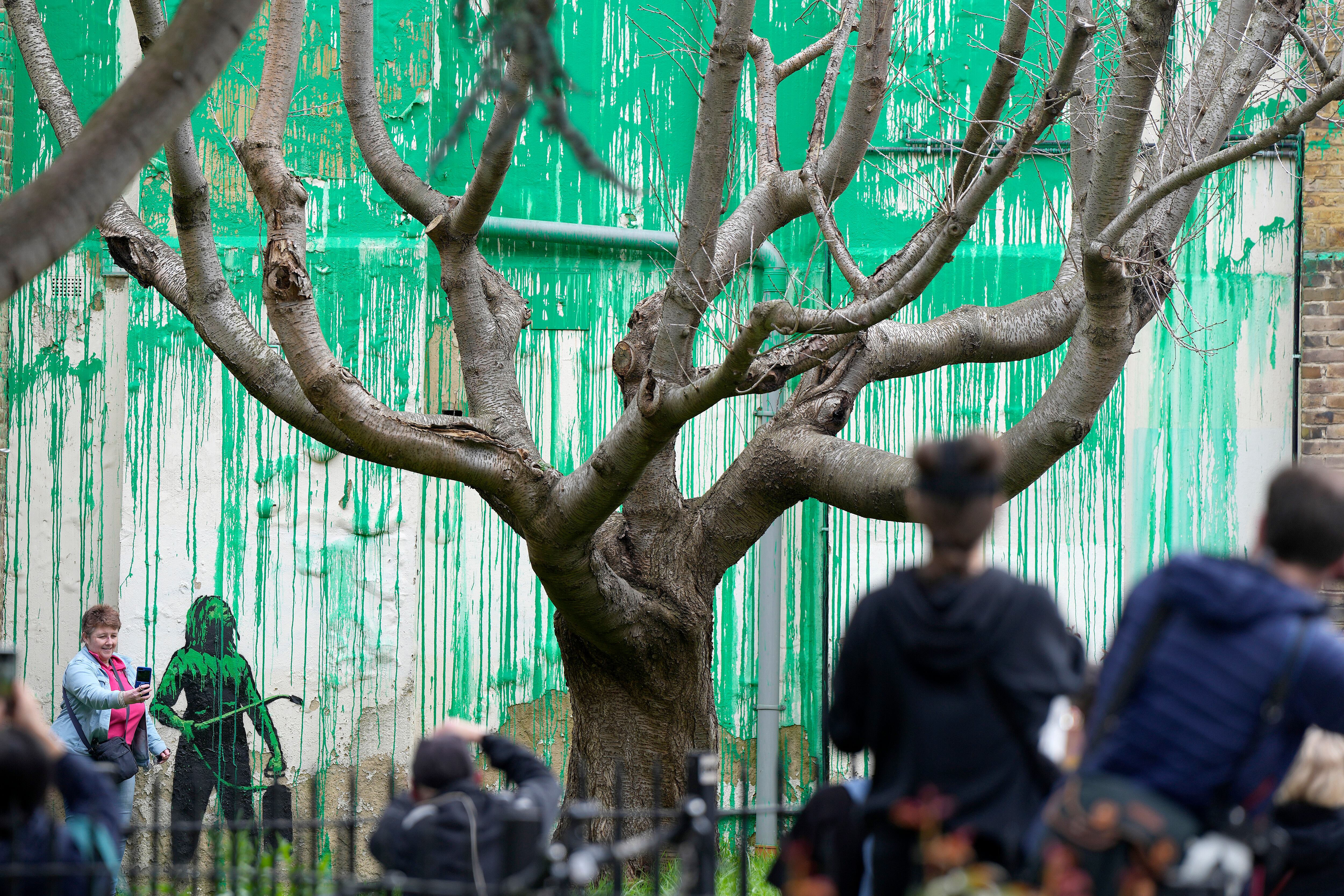 La gente mira una nueva pintura de Banksy en una pared en Londres, el lunes 18 de marzo de 2024. Un nuevo mural de Banksy atrajo multitudes a una calle de Londres el lunes, incluso antes de que el esquivo artista de graffiti confirmara que la obra era suya.