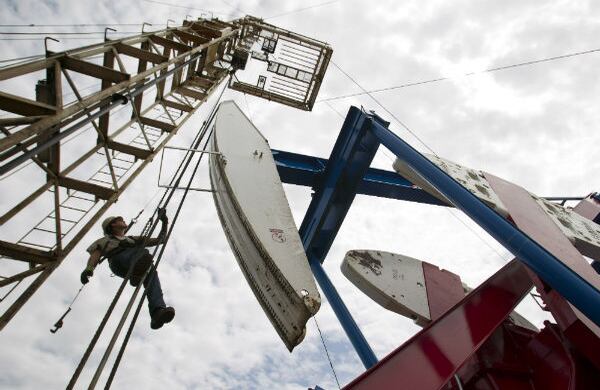 El trabajador Ben Shaw cuelga de una de las grúas de extracción de petróleo en Dakota del Norte, Estados Unidos. (AP)