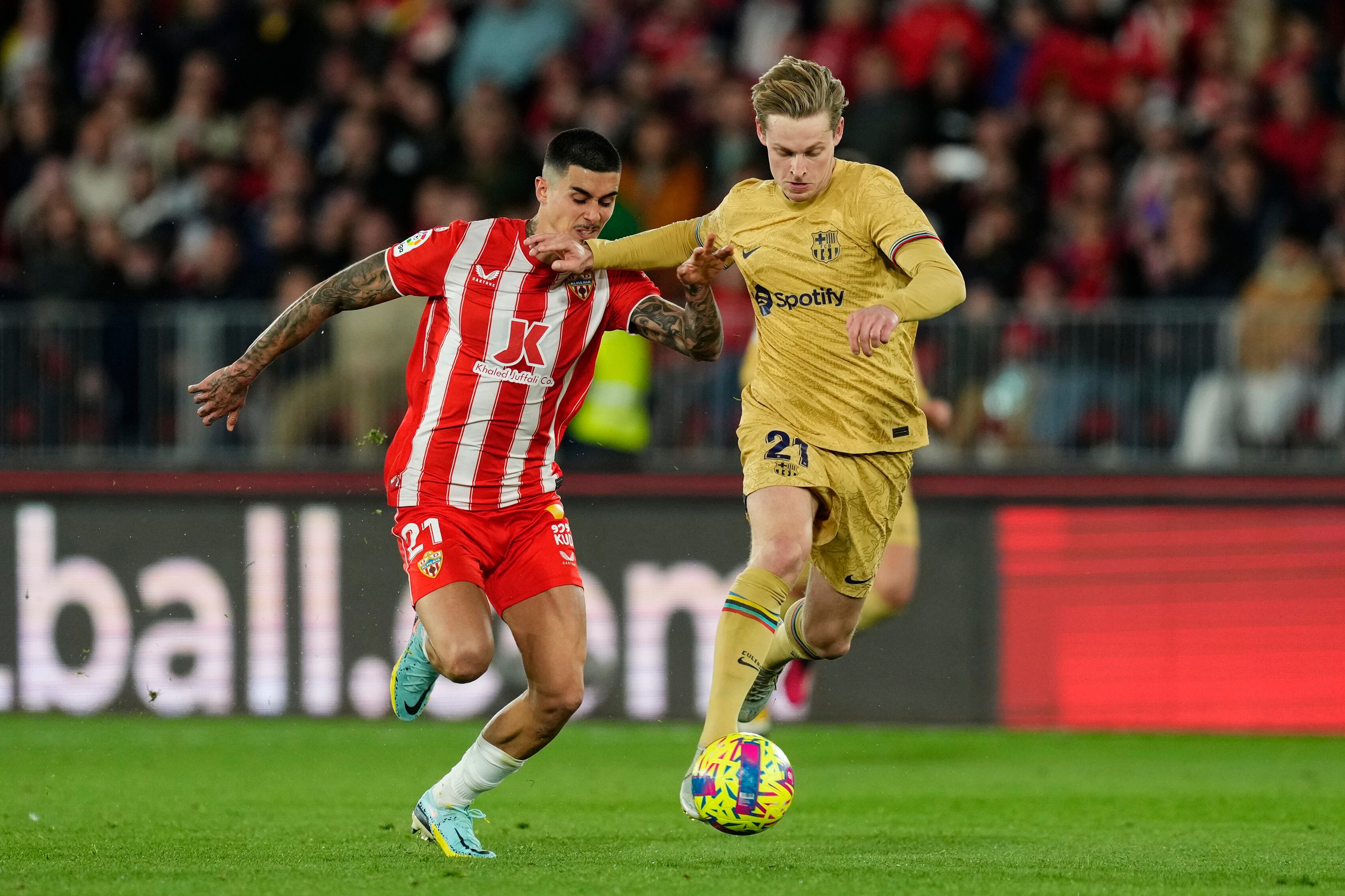 Barcelona's Frenkie de Jong, right, vies for the ball with Almeria's Srdan Babic during the Spanish La Liga soccer match between Almeria and Barcelona at the Juegos Mediterraneos stadium in Almeria, Spain, Sunday, Feb. 26, 2023. Almeria won 1-0. (AP Photo/Jose Breton)