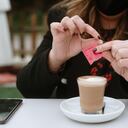 A young woman having a coffee wearing a protective face mask