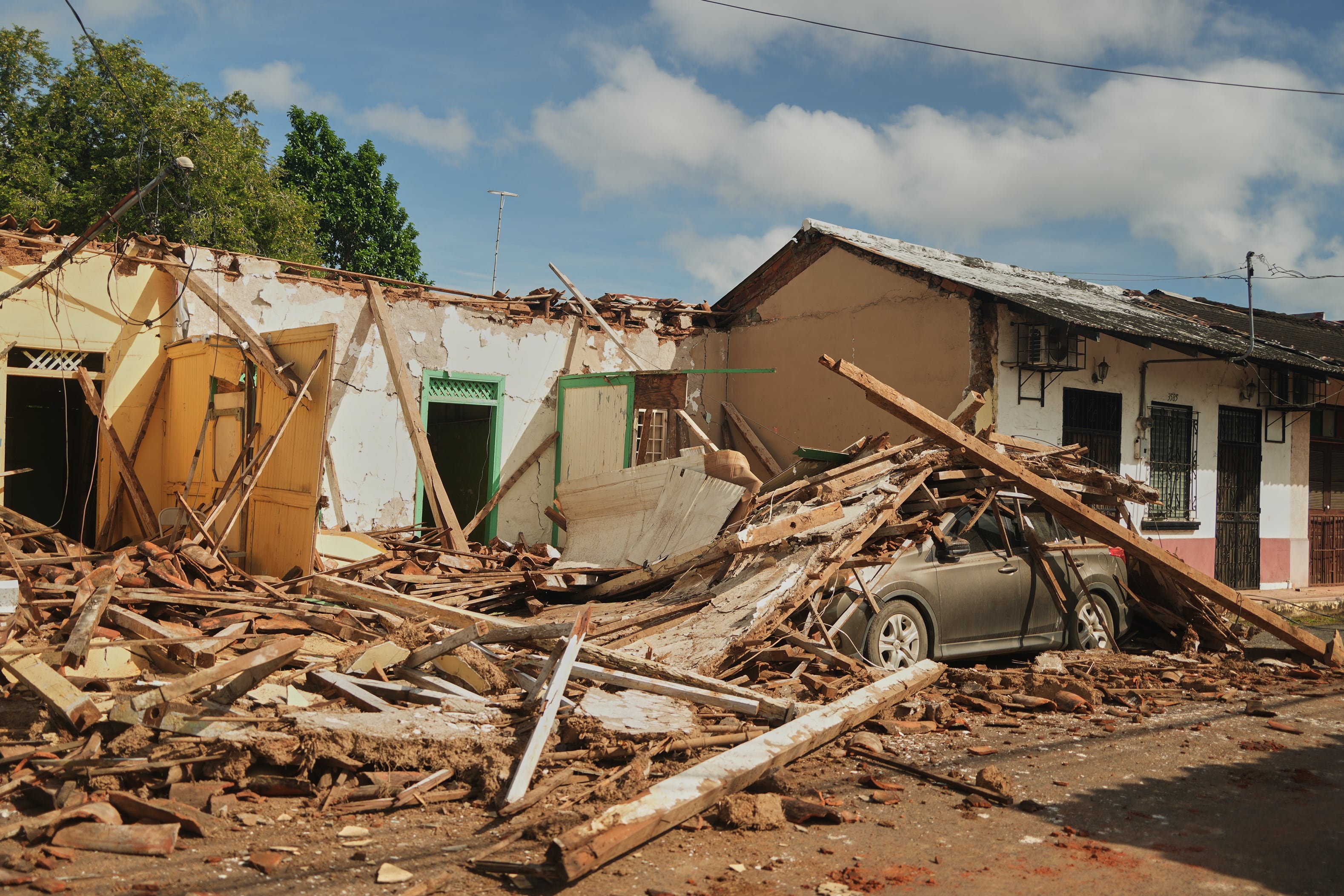 Un automóvil aparece cubierto de escombros de casas dañadas por un terremoto en Villa de los Santos, Panamá.