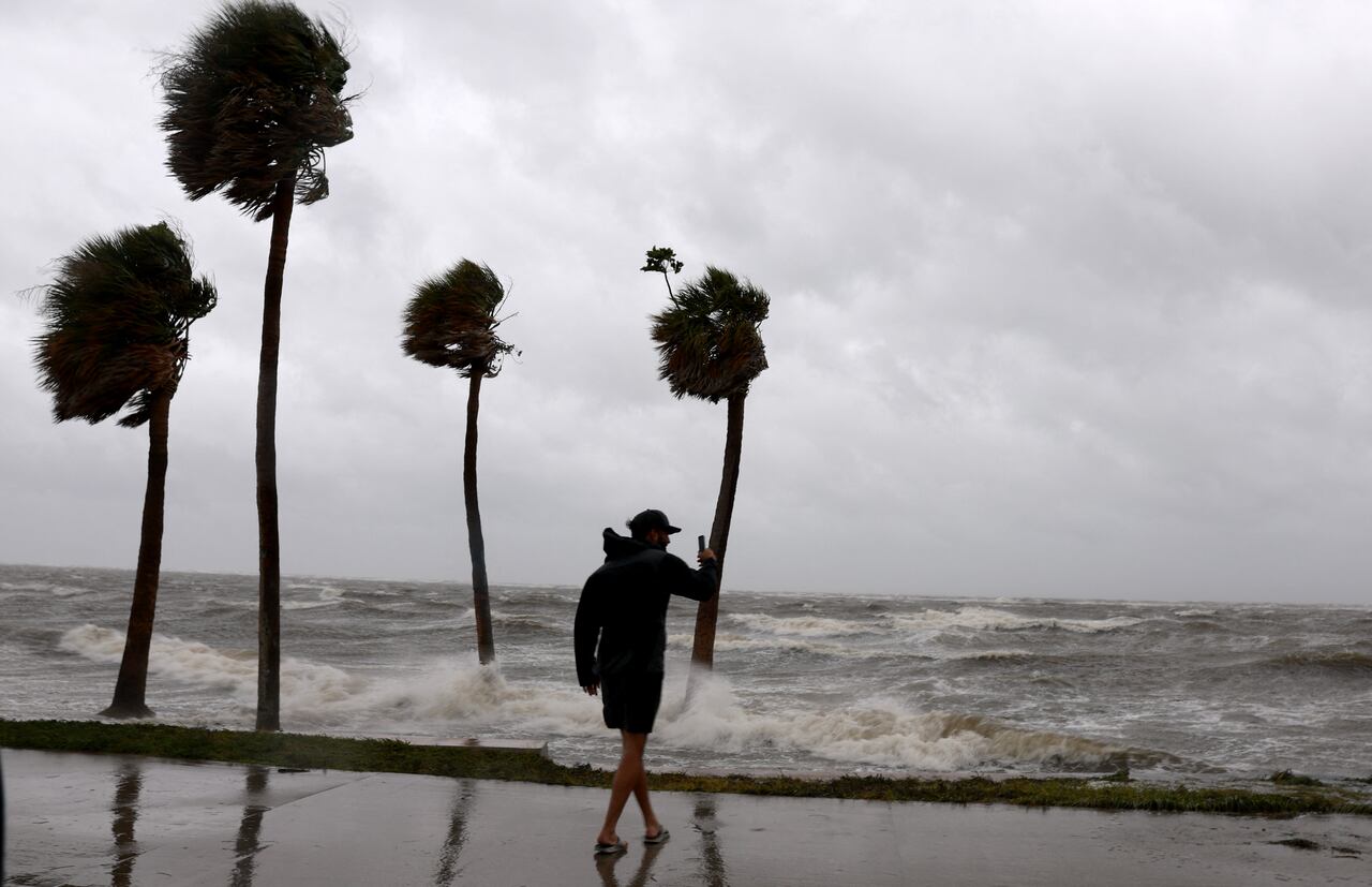 La gente camina bajo el viento y la lluvia junto a la Bahía de Tampa mientras el huracán Helene azota la costa el 26 de septiembre de 2024, en San Petersburgo, Florida.