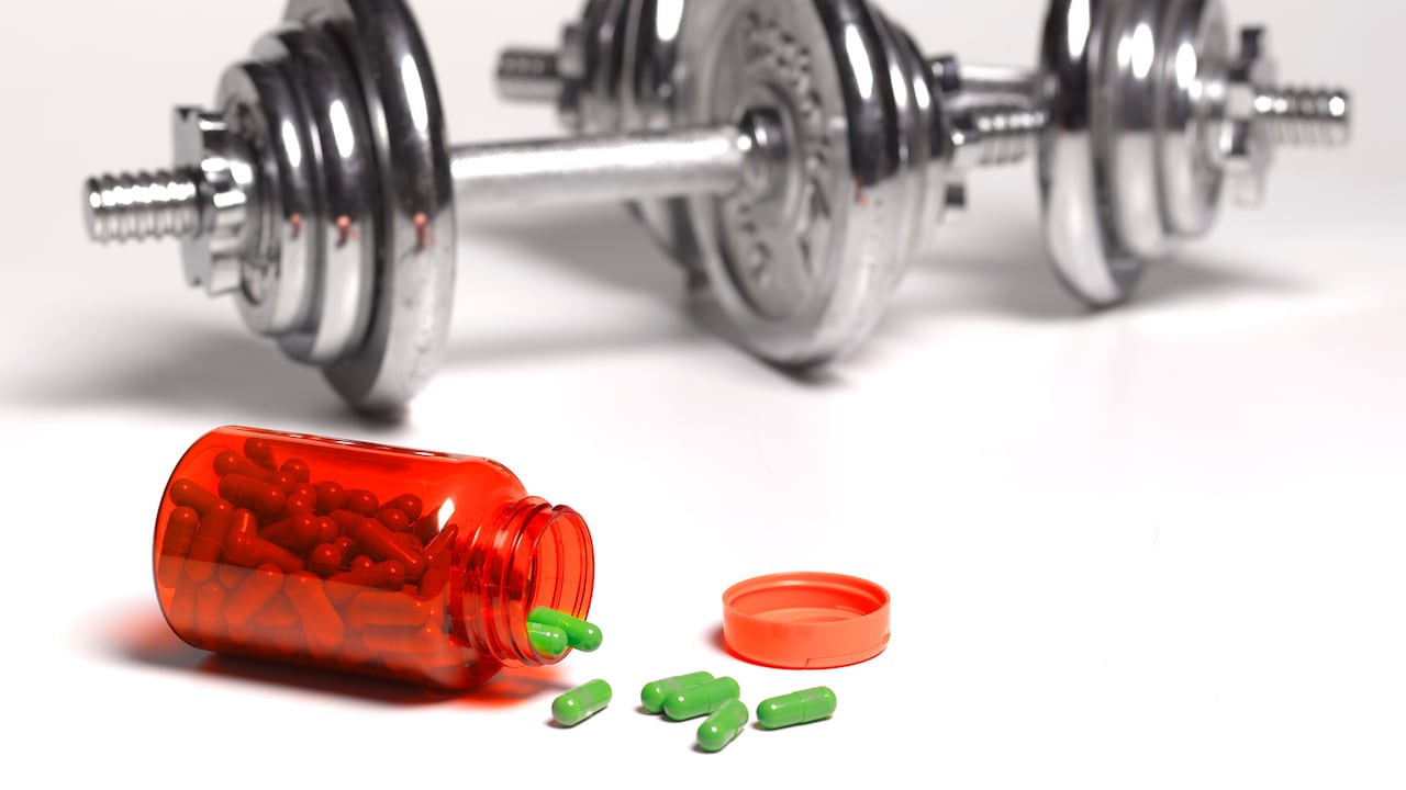 Pesas con mancuernas de gimnasio, además de unas pastillas