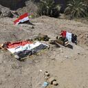 Vista de fosas clandestinas de la supuesta tumba de milicianos del Estado Islámico (EI) en la base de Spiker, junto a la bandera de Irak. (Efe)