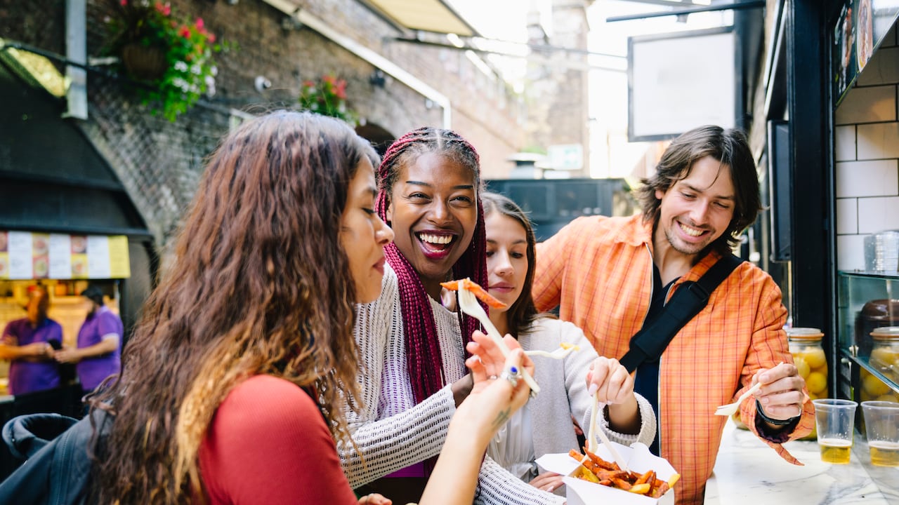 Amigos turistas probando nuevos platos durante sus viajes