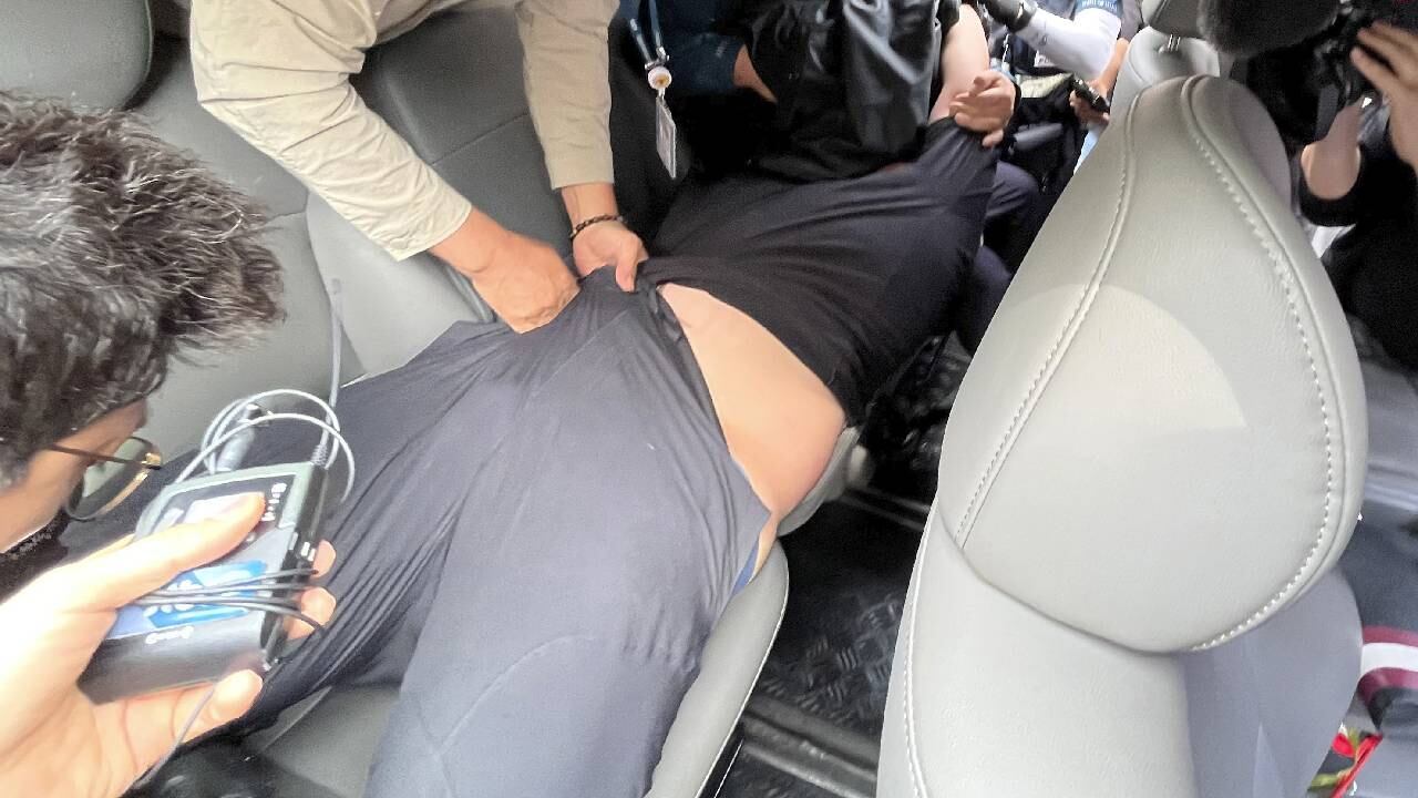 Oficiales de policía vestidos de civil arrestan a un pasajero de avión en el Aeropuerto Internacional de Daegu, Corea del Sur.