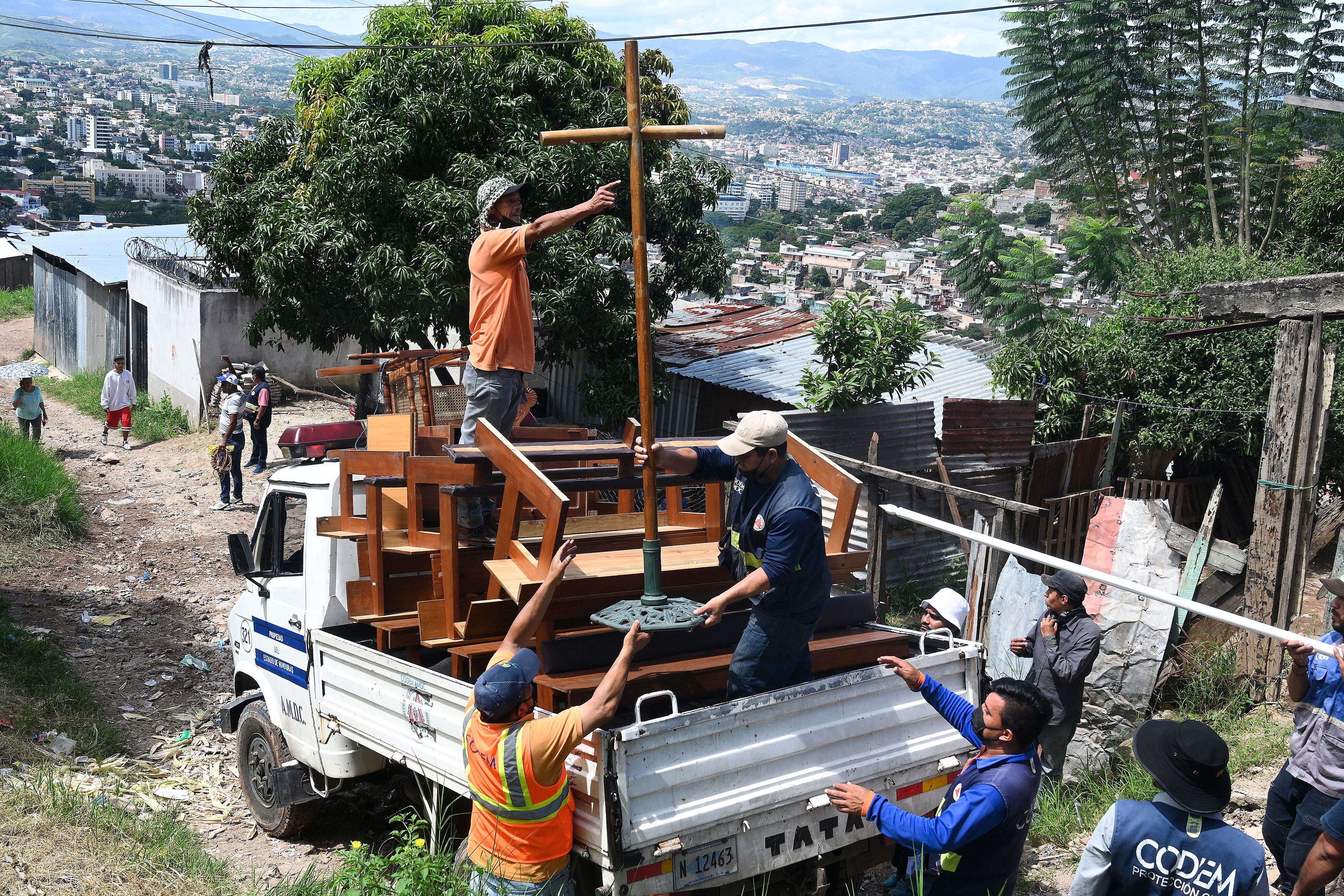 Hondureños abandonan sus viviendas luego de que muchas se derrumbaron por los aguaceros. (Photo by ORLANDO sierra / AFP)