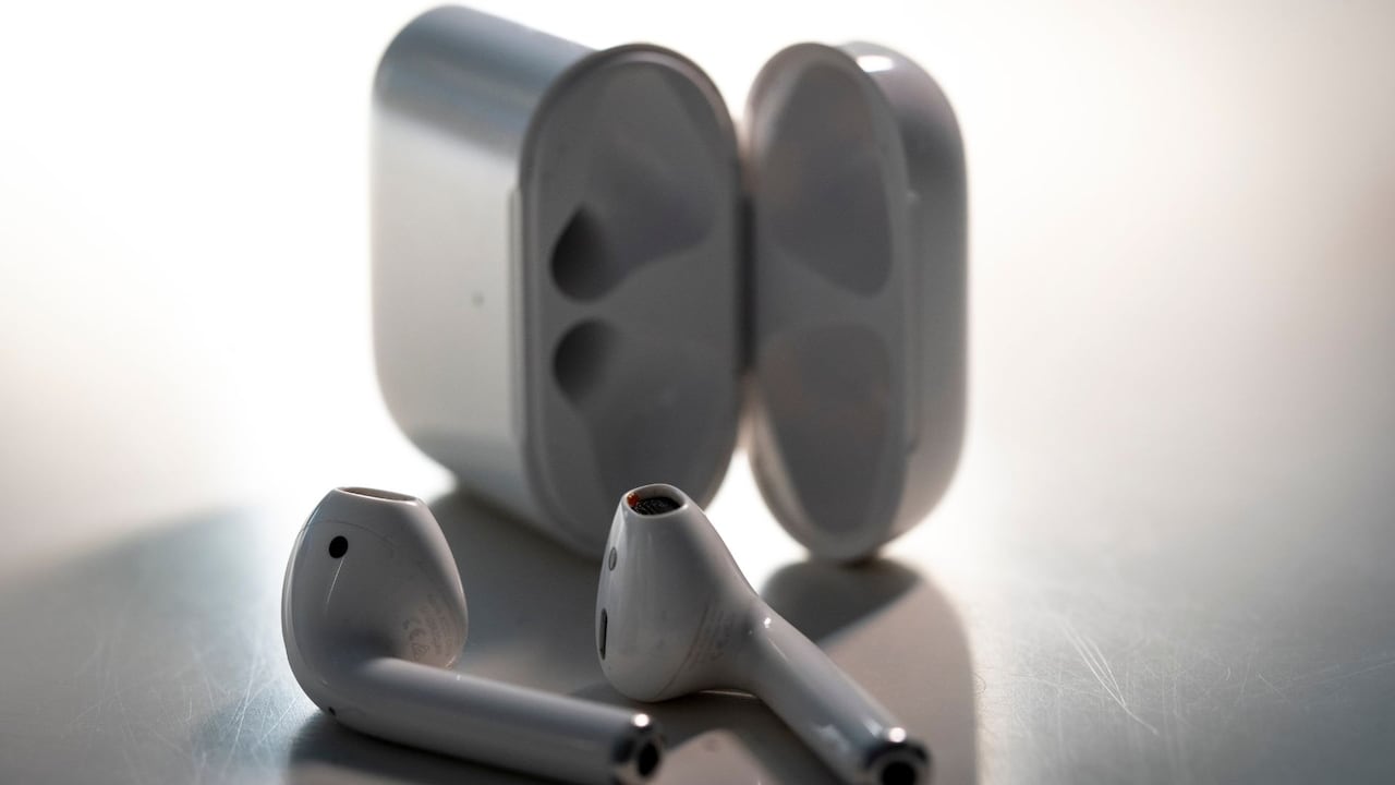 Auriculares inalámbricos junto a su estuche.