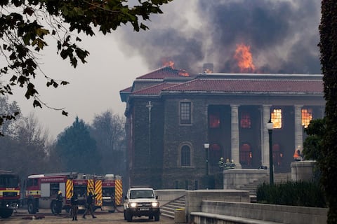 Los bomberos intentan extinguir un incendio en la Biblioteca Jagger de la Universidad de Ciudad del Cabo. El 18 de abril de 2021, un incendio forestal bajó por las faldas de la Montaña de la Mesa, incendiando edificios universitarios en Ciudad del Cabo. Foto de Rodger Bosch / AFP