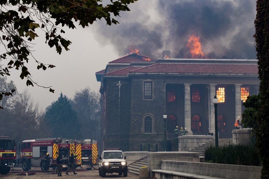 Los bomberos intentan extinguir un incendio en la Biblioteca Jagger de la Universidad de Ciudad del Cabo. El 18 de abril de 2021, un incendio forestal bajó por las faldas de la Montaña de la Mesa, incendiando edificios universitarios en Ciudad del Cabo. Foto de Rodger Bosch / AFP