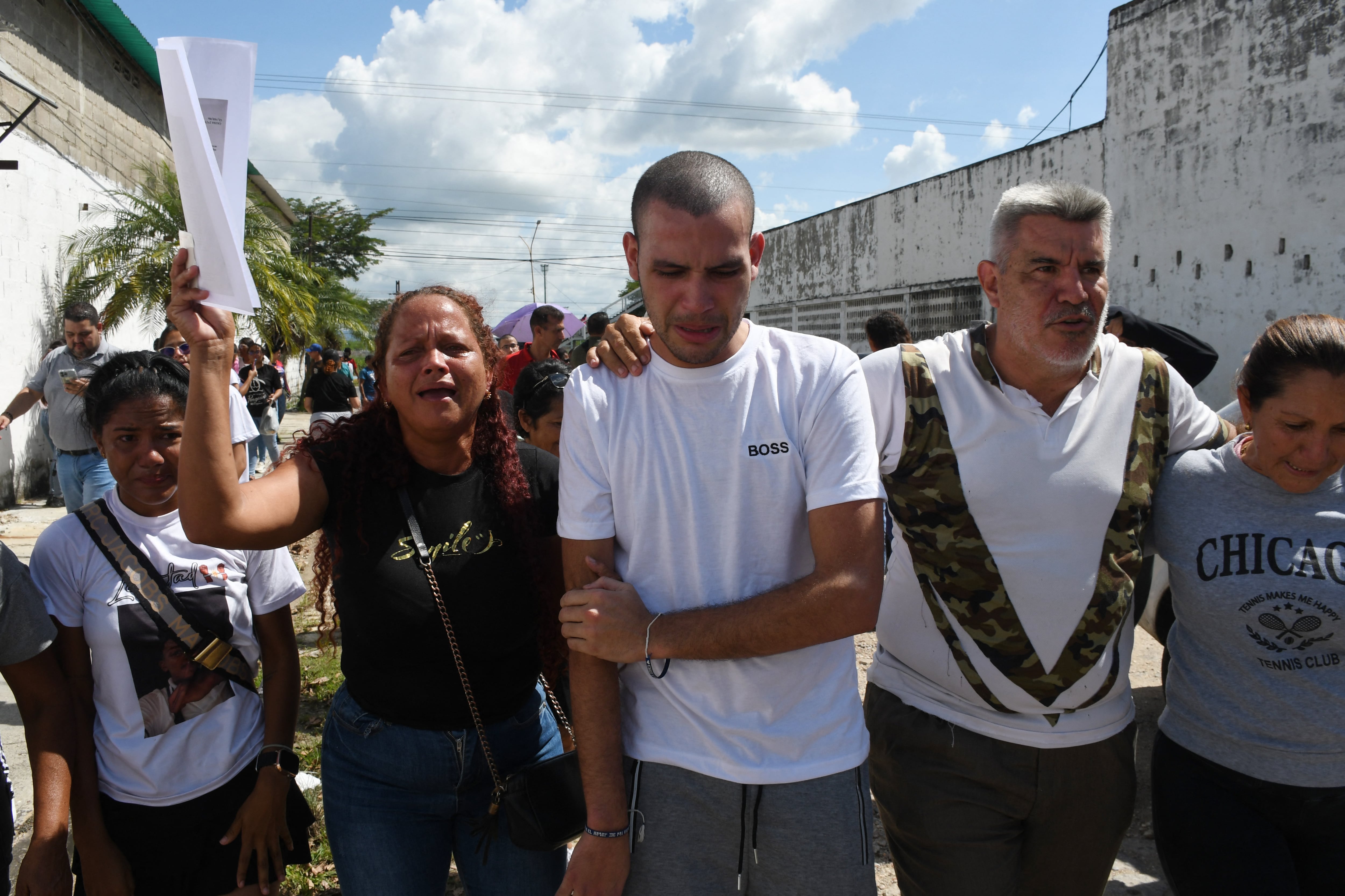 Un hombre arrestado durante las protestas posteriores a las disputadas elecciones presidenciales del 28 de julio camina junto a sus familiares después de su liberación frente a la prisión de Tocuyito, en Tocuyito, estado de Carabobo, Venezuela, el 16 de noviembre de 2024. (Foto de Gabriela Pérez / AFP)