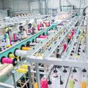 Máquina de bordar en funcionamiento en una fábrica de ropa - conceptos de la industria de la moda