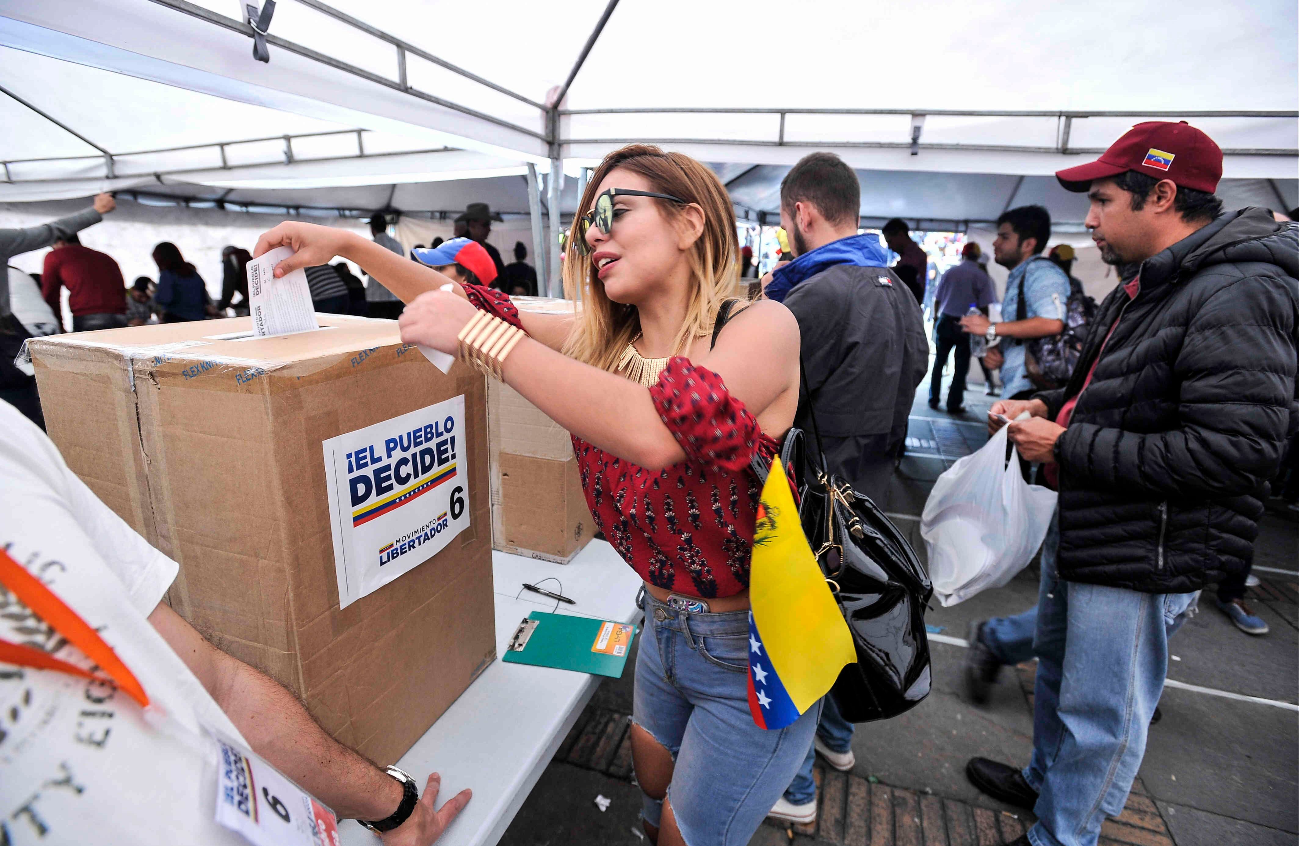 . Una venezolana —residente en Bogotá— sufraga el domingo 16 de julio de 2017 en Colombia, durante las votaciones al plebiscito. Esta jornada democrática ha sido  impulsada  por la oposición al gobierno de Nicolás Maduro. En las tarjetas, los ciudadanos deben responder ‘sí’ o ‘no’ a tres preguntas: la primera es si respalda el plan del presidente Nicolás Maduro de cambiar la Constitución; la segunda es si  apoya la intervención de las Fuerzas Armadas para “restituir el orden constitucional” y por último si desea un gobierno de unidad nacional. Foto: Carlos Julio Martínez / SEMANA