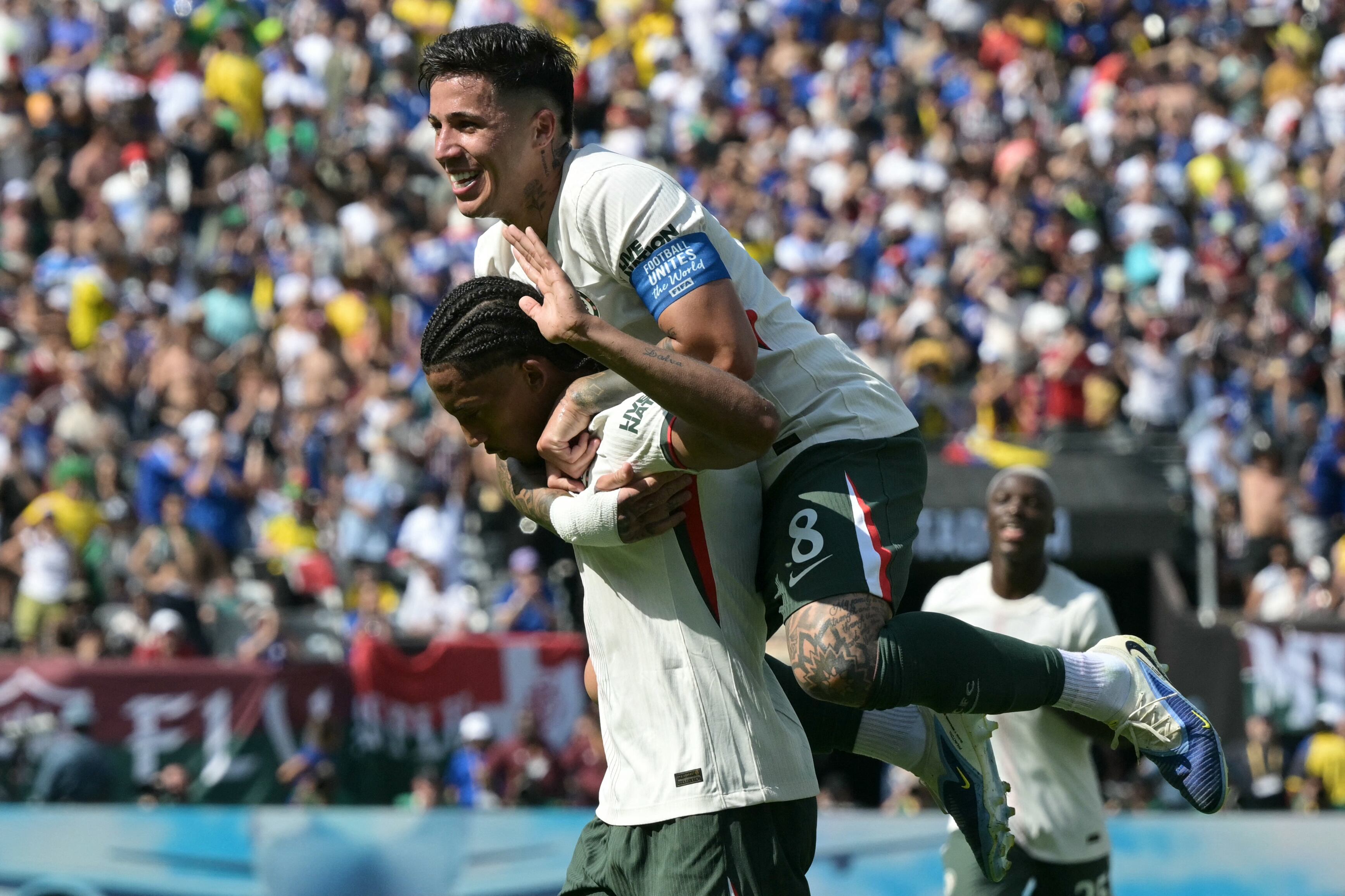 El delantero brasileño #20 del Chelsea, Joao Pedro, celebra el segundo gol de su equipo con el mediocampista argentino #08 Enzo Fernández durante el partido de semifinales de la Copa Mundial de Clubes de la FIFA 2025.