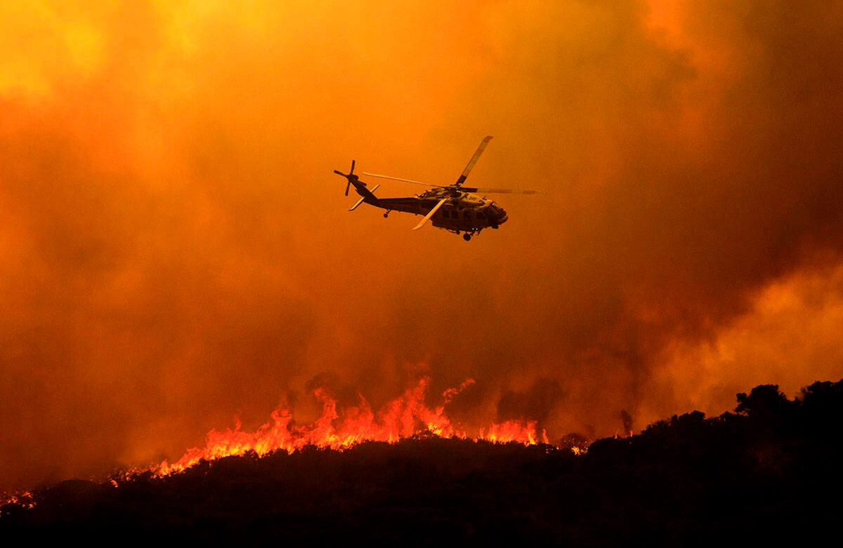 Un helicóptero se prepara para arrojar agua sobre el incendio del lago Hughes en el Bosque Nacional Ángeles el miércoles,12 de agosto de 2020, al norte de Santa Clarita, California. Foto: Ringo H.W. Chiu / AP 