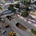 Un socavón está expuesto en la carretera principal de Villa Nueva, Guatemala, el domingo 25 de septiembre de 2022.