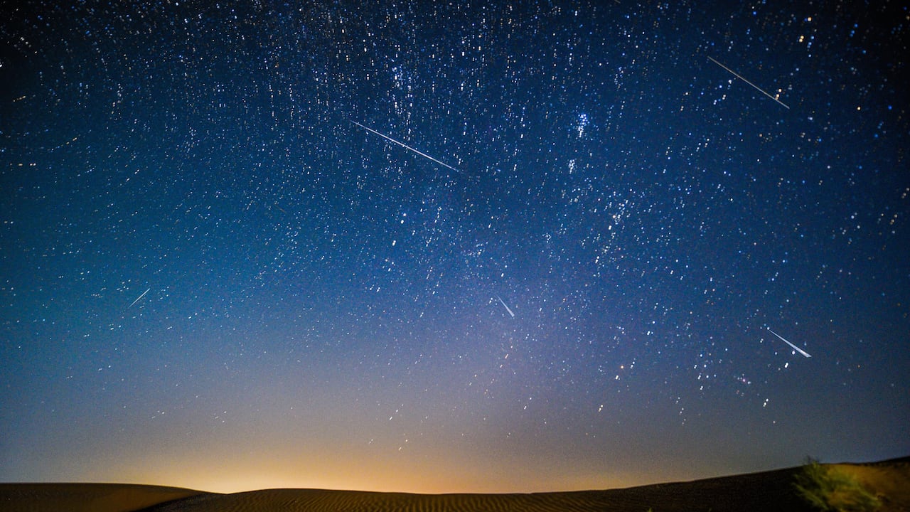 Fotomontaje tomado el 13 de agosto de 2021 que muestra el cielo nocturno durante la lluvia de meteoritos de las Perseidas sobre una zona de demostración ecológica de Engebei en el desierto de Kubuqi