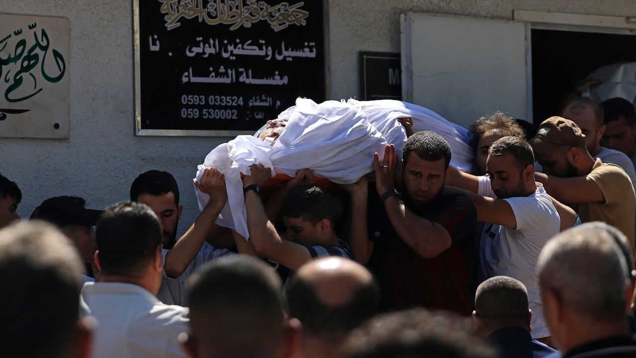 NOTA DEL EDITOR: Contenido gráfico / Dolientes llevan el cuerpo de un palestino fallecido en la última operación de infiltración en Israel, fuera del hospital al-Shifa en la Ciudad de Gaza el 7 de octubre de 2023. Según funcionarios israelíes, militantes palestinos han iniciado una "guerra" contra Israel, infiltrándose por aire, mar y tierra desde la bloqueada Franja de Gaza, lo que representa una escalada importante en el conflicto israelí-palestino. (Foto de MAHMUD HAMS / AFP).