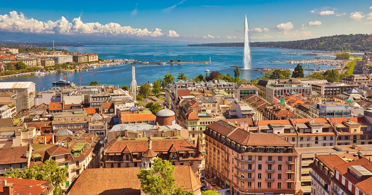 Paisaje urbano de Ginebra, franco-suizo en Suiza. Vista aérea de la fuente Jet d'eau, el lago Lemán, la bahía y el puerto desde el campanario de la Catedral de San Pedro. Cielo azul en un día soleado.