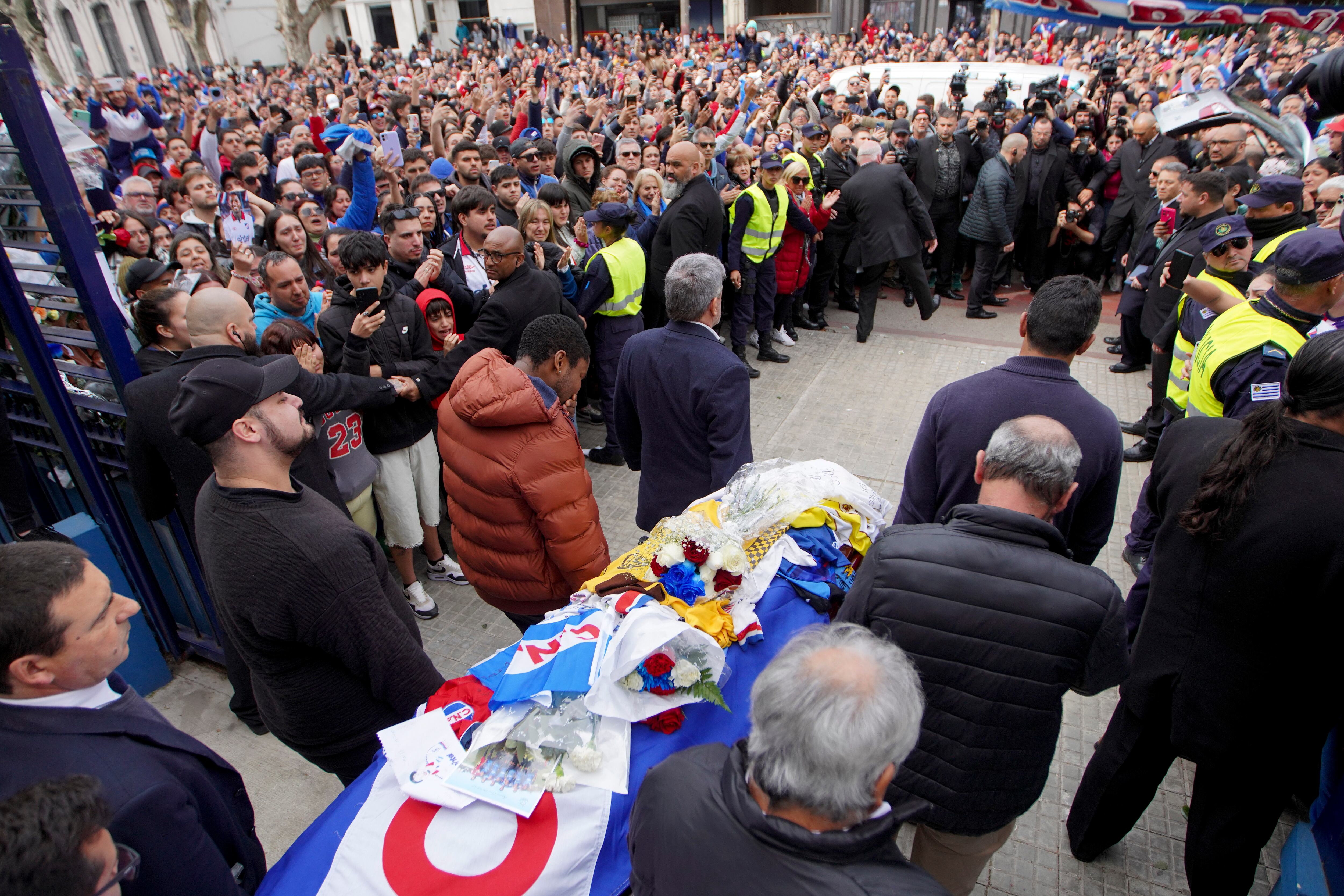 Family and friends of soccer player Juan Izquierdo carry his coffin out of his soccer club Nacional where a wake was held in Montevideo, Uruguay, Thursday, Aug. 29, 2024. Izquierdo died at a Brazilian hospital after collapsing on Aug. 22 during a Copa Libertadores soccer match between Nacional and Sao Paulo. (AP Photo/Matilde Campodonico)