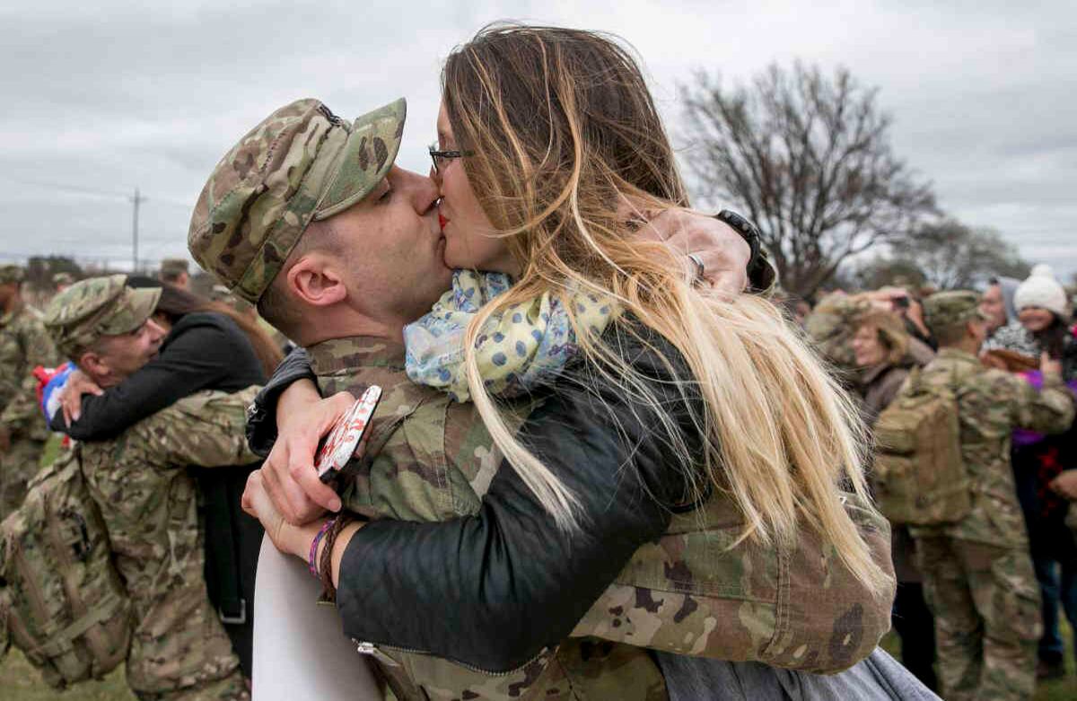 Capt. Thomas DiMiero besa a su esposa, Jennifer DiMiero, durante una ceremonia de bienvenida en Fort Hood, Texas, el martes, 14 de febrero de 2017. La pareja se reunió después de su despliegue de nueve meses en Afganistán, donde sirvió con 199 soldados de la 3ro regimiento de caballería del ejército. (Jay Janner / Austin American-Statesman via AP)