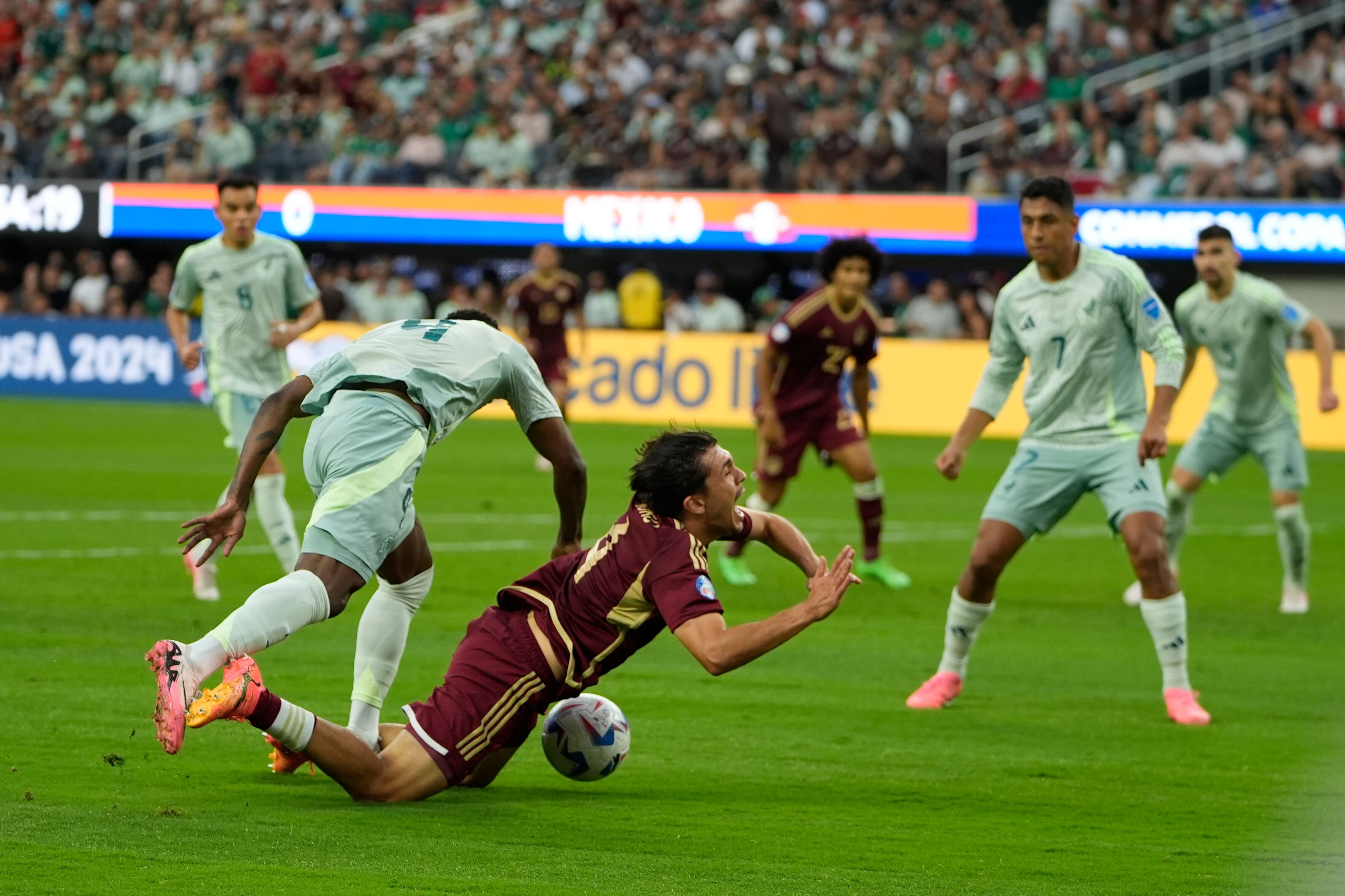 Mexico's Julian Quinonez, left, fouls Venezuela's Jon Aramburu during a Copa America Group B soccer match Wednesday, June 26, 2024, in Inglewood, Calif. (AP Photo/Ryan Sun)
