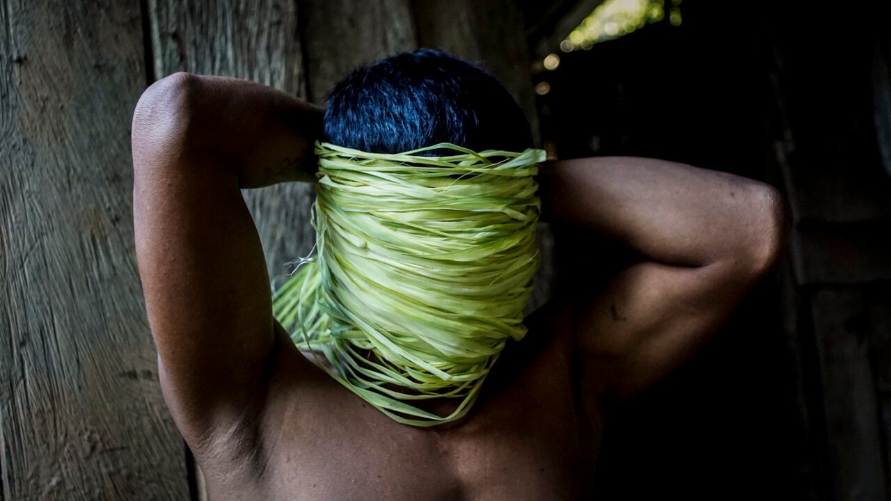 Luis tapa su cara con hojas de chambira, planta utilizada por los Cocama anteriormente para fabricar sus vestidos. Esta hoja es utilizada actualmente solo para hacer hamacas.