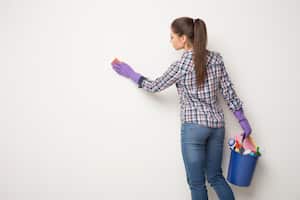 Mujer limpiando una pared. Imagen de referencia.