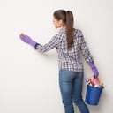 Mujer limpiando una pared. Imagen de referencia.