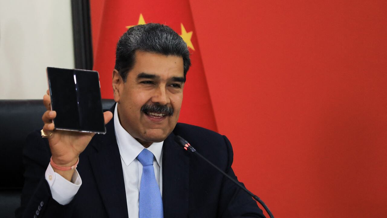 En esta fotografía publicada por la oficina de prensa de Miraflores, el presidente de Venezuela, Nicolás Maduro, muestra un teléfono móvil que le regaló el presidente chino, Xi Jinping, mientras habla durante una conferencia con la prensa internacional en Beijing el 14 de septiembre de 2023. El presidente venezolano, Nicolás Maduro, ha dicho que su país podría pronto enviará a sus primeros astronautas a la Luna en una nave espacial china, saludando el 14 de septiembre un acuerdo de cooperación científica alcanzado con el presidente Xi Jinping. (Foto de JHONN ZERPA / Presidencia de Venezuela / AFP) / RESTRINGIDO A USO EDITORIAL - CRÉDITO OBLIGATORIO "AFP FOTO / PRESIDENCIA DE VENEZOLANA / Jhonn ZERPA" - SIN MARKETING - SIN CAMPAÑAS PUBLICITARIAS - DISTRIBUIDO COMO SERVICIO A CLIENTES