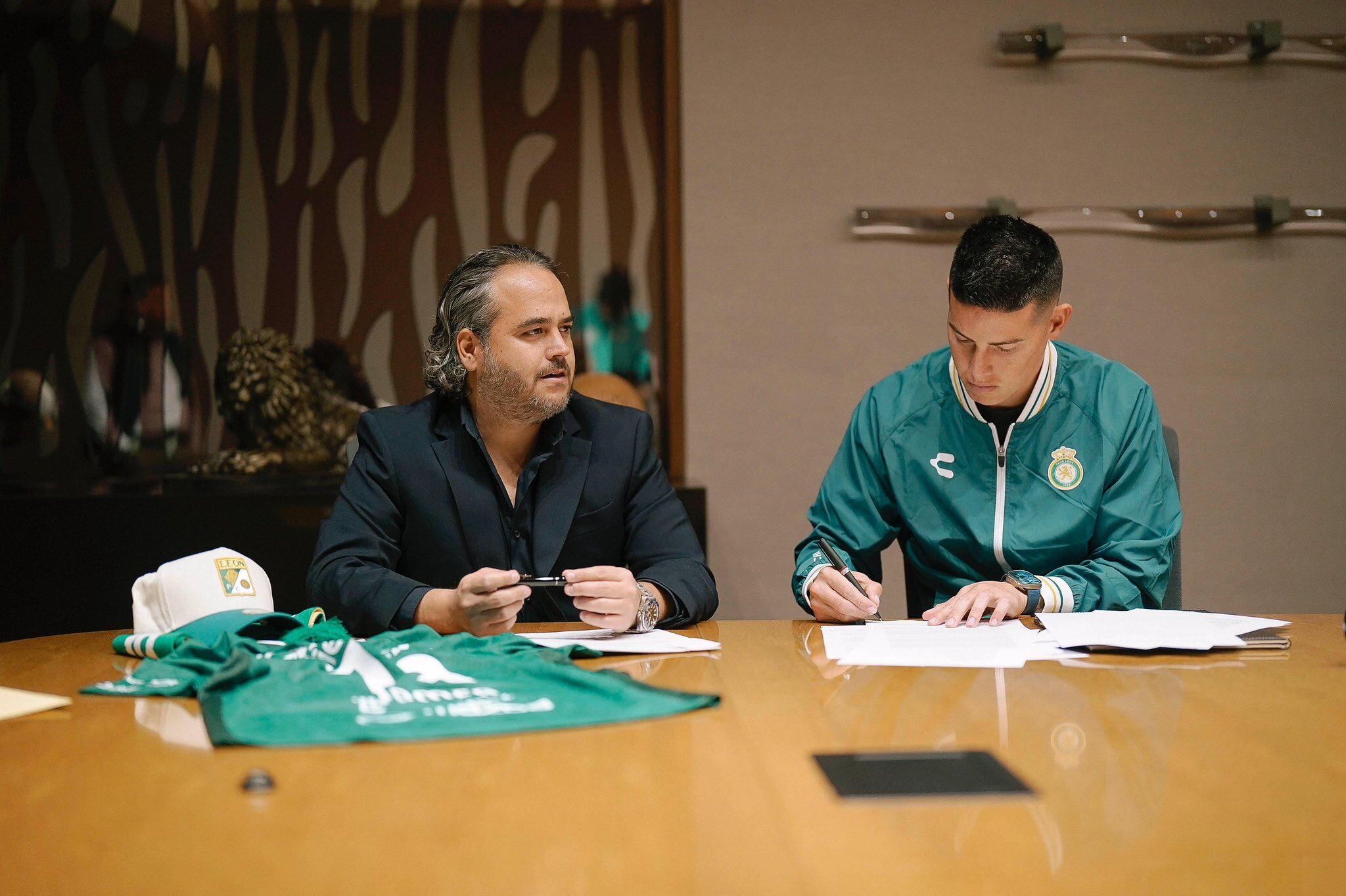 James Rodríguez (izquierda) firmando su contrato con el Club León, al lado del presidente Jesús Martínez Murguía (derecha).