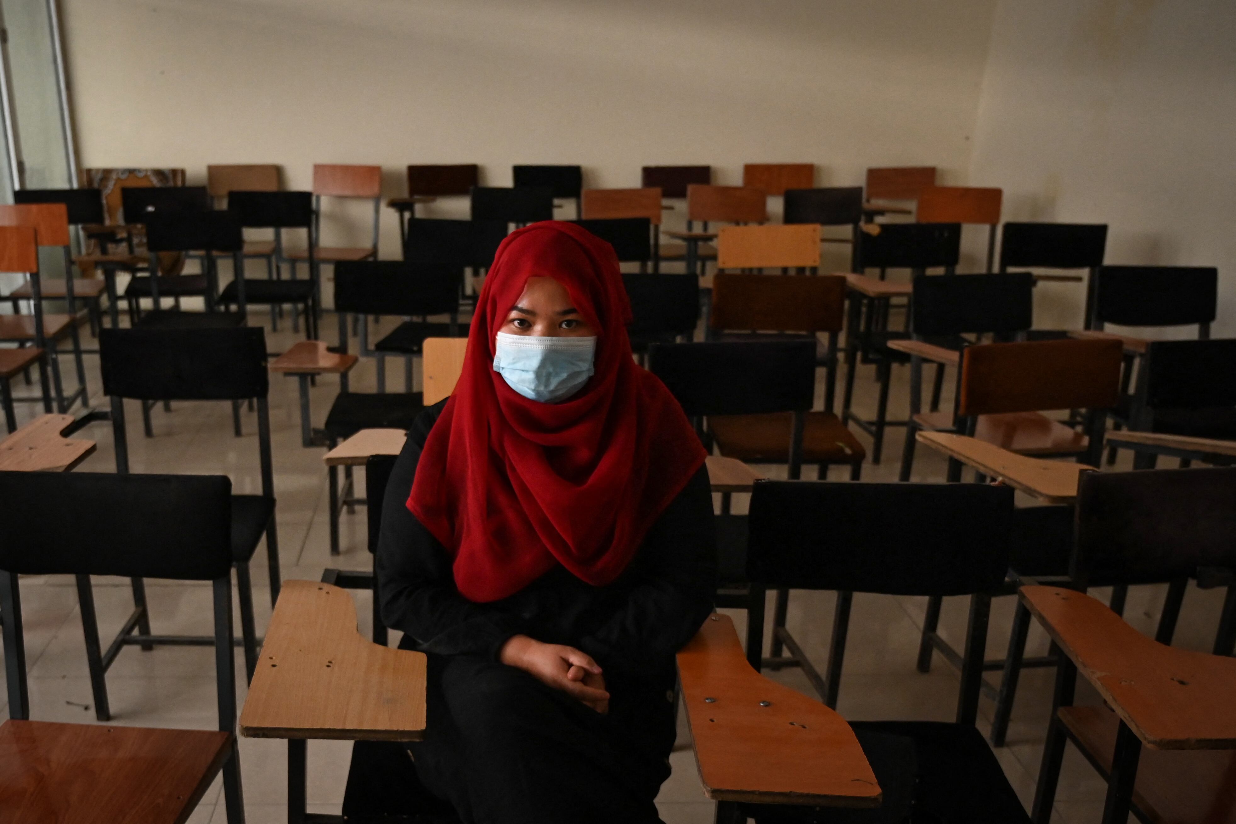Un estudiante se sienta dentro de un aula después de que las universidades privadas reabrieran en Kabul el 6 de septiembre de 2021. - Las mujeres que asisten a universidades privadas afganas deben usar una bata abaya y un niqab que cubra la mayor parte de la cara, han ordenado los talibanes, y las clases deben estar segregadas por sexo - - o al menos dividido por una cortina. (Foto de Aamir QURESHI / AFP)