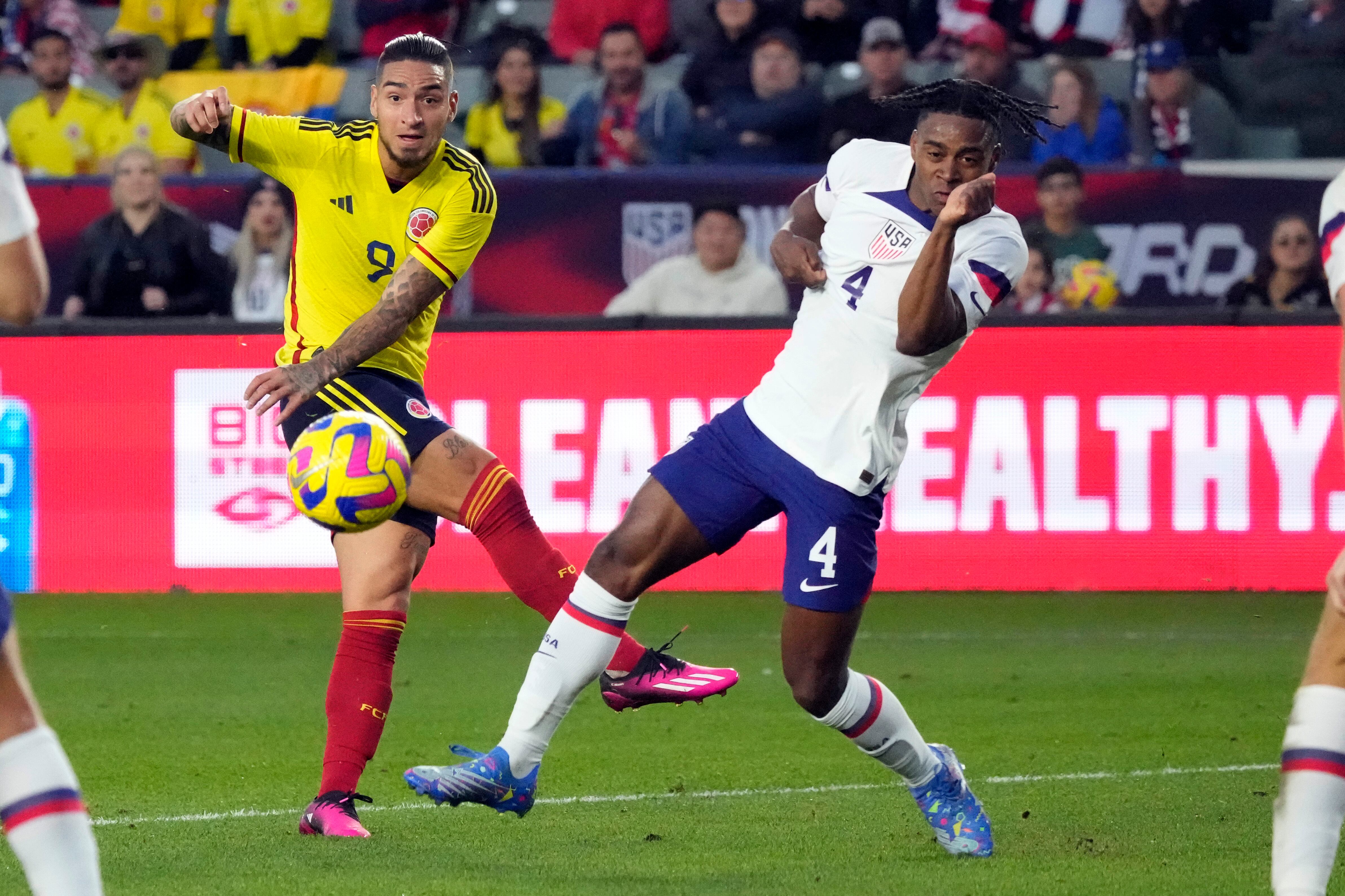 Colombia's Cristian Arango, left, takes a shot on goal next to United States' DeJuan Jones during the first half of an international friendly soccer match Saturday, Jan. 28, 2023, in Carson, Calif. (AP Photo/Marcio Jose Sanchez)