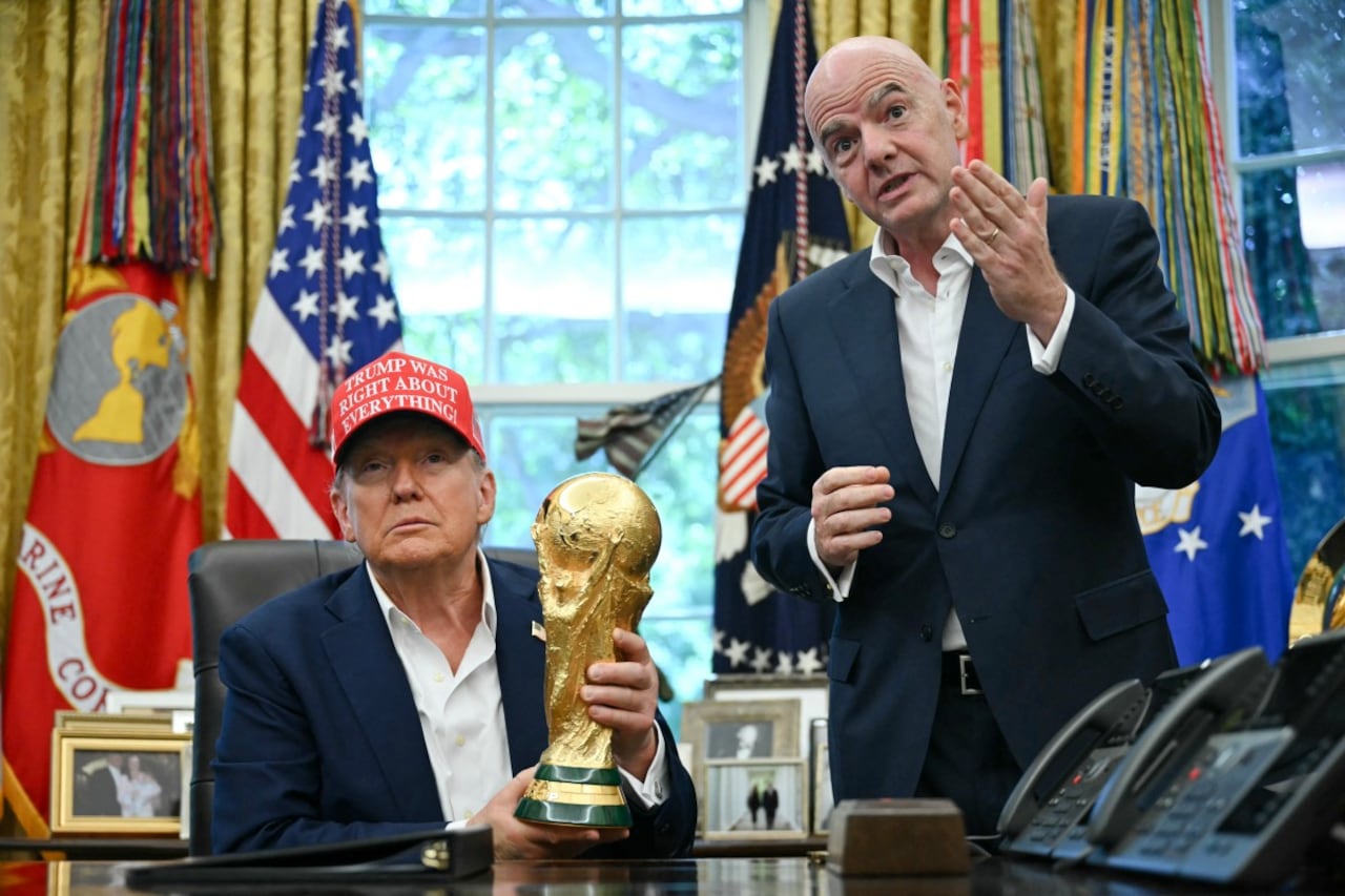 El presidente de Estados Unidos, Donald Trump, acompañado por el presidente de la FIFA, Gianni Infantino (derecha), sostiene el trofeo de la Copa del Mundo mientras hace un anuncio en la Oficina Oval.