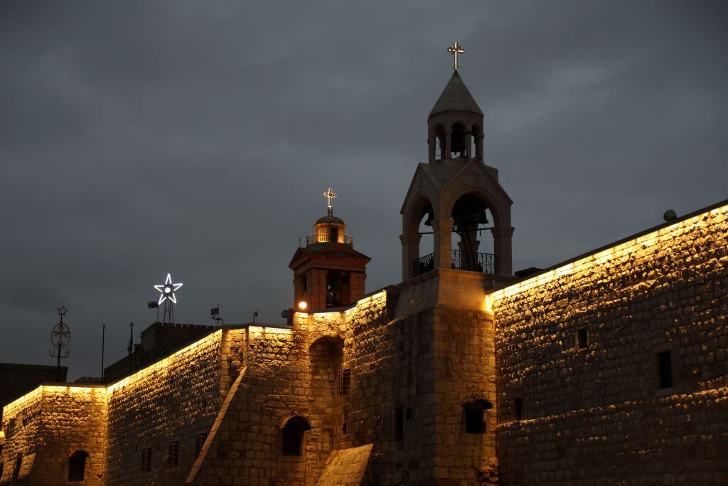 BETHLEHEM, WEST BANK - DECEMBER 23: A general view of the Church of the Nativity, built on a cave where Jesus Christ is believed to have been born, with only one side illuminated as all Christmas celebrations are limited due to the Israeli-Palestinian conflict in Bethlehem, West Bank on December 23, 2023. Due to Israel's attacks on Gaza, the streets of the city were not decorated for Christmas this year as in previous years. In the city, where festive activities were avoided, the streets were not decorated with lights as in previous years and the Christmas tree in front of the Church of the Nativity (Mehd) was not illuminated. While the courtyard of the Church of the Nativity is filled with visitors every year, this year it was almost empty. (Photo by Wesam Hashlamon/Anadolu via Getty Images)