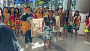 Adriana Martínez Dogirama llegando al aeropuerto El Dorado, en Bogotá. Atrás, su comunidad indígena dándole la bienvenida