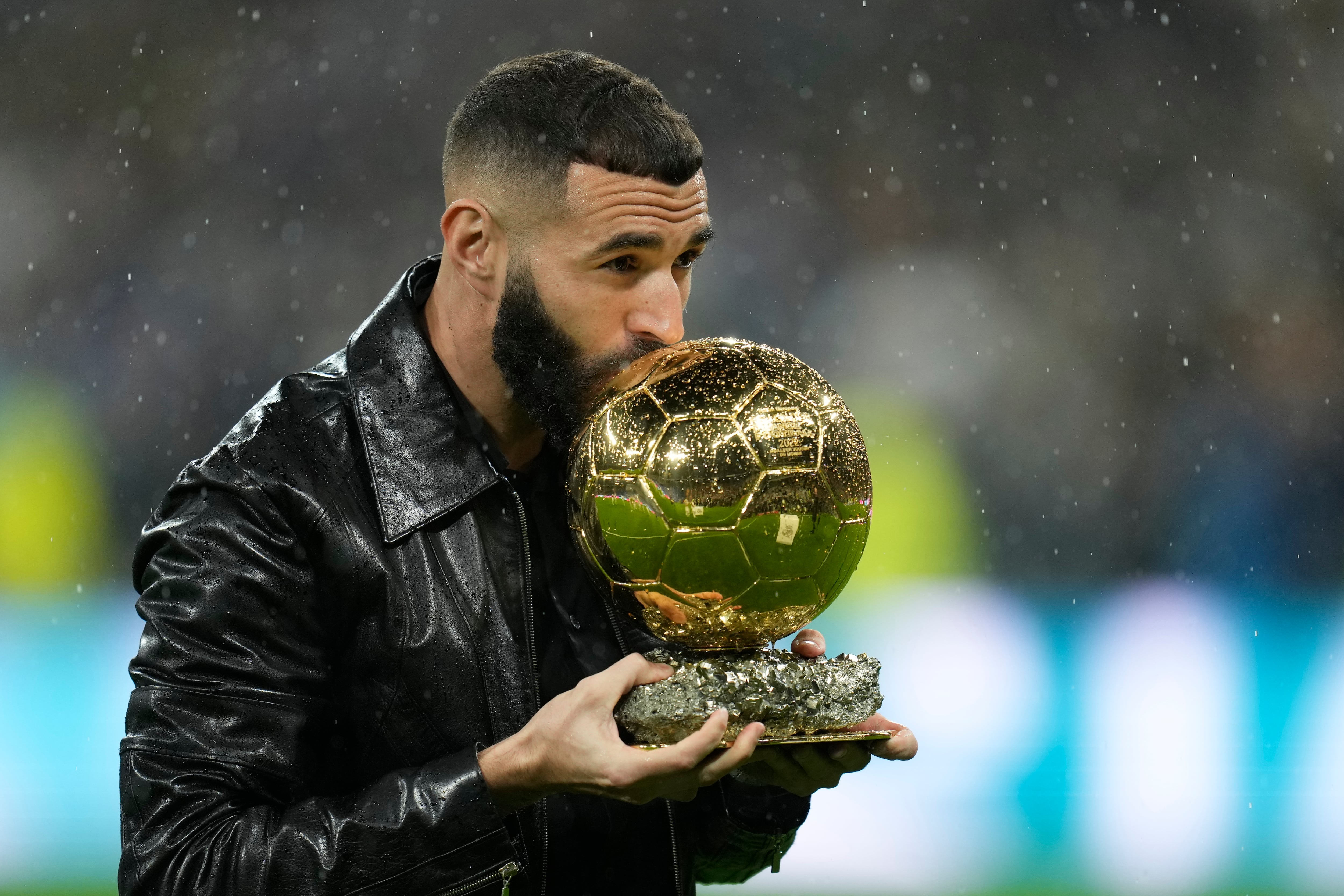 Real Madrid's Karim Benzema kisses the 2022 Ballon d'Or trophy prior to the Spanish La Liga soccer match between Real Madrid and Sevilla at the Santiago Bernabeu stadium in Madrid, Saturday, Oct. 22, 2022. (AP Photo/Manu Fernandez)