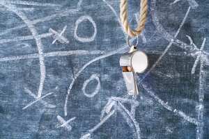 whistle of a soccer or football referee on black board with strategy diagram scribble, free copy space