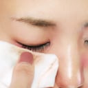 Mujer retirando el maquillaje de sus ojos.